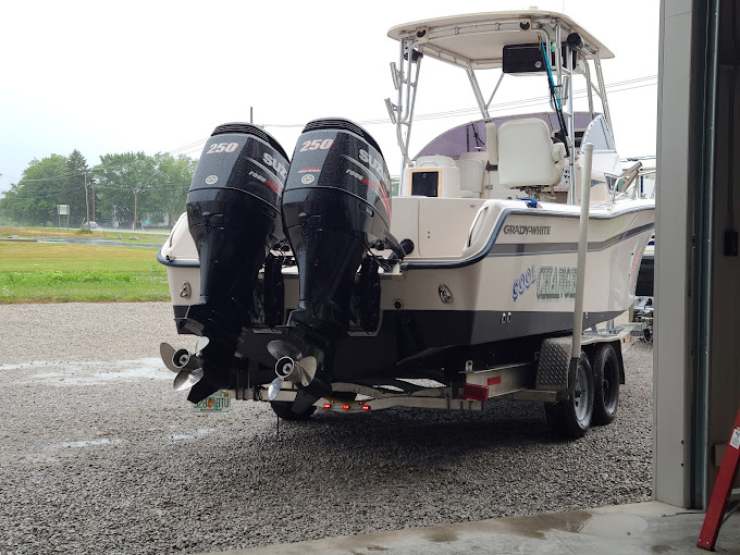 Tan dual outboard boat on display